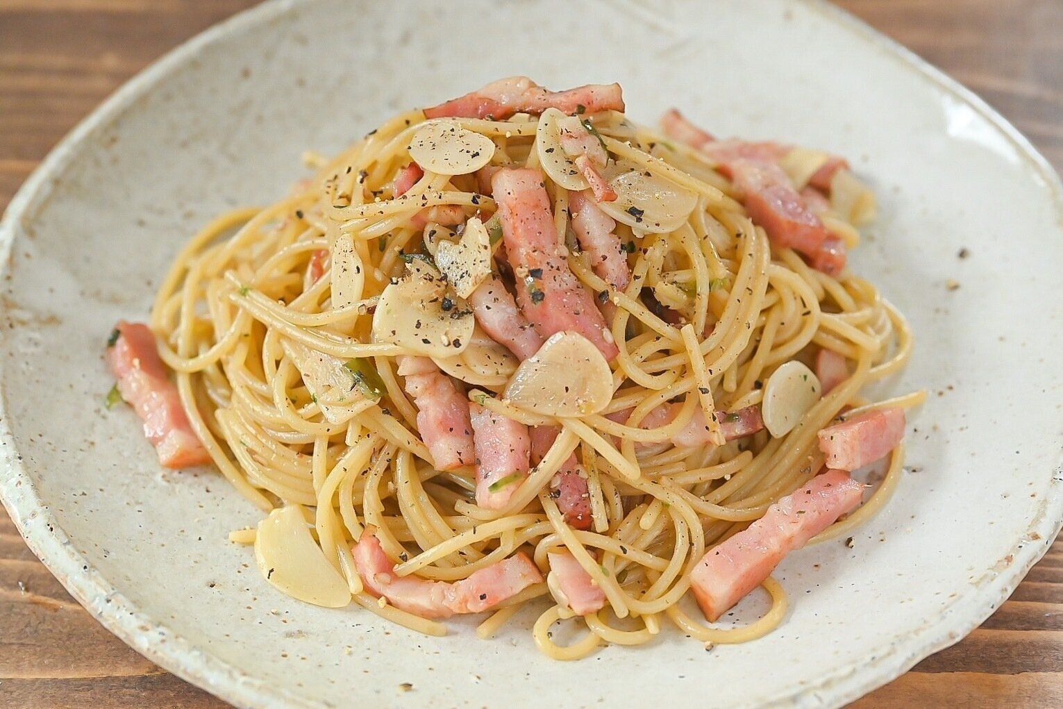 陶器の皿に盛ったベーコンと「青いにんにく辣油」　のパスタ