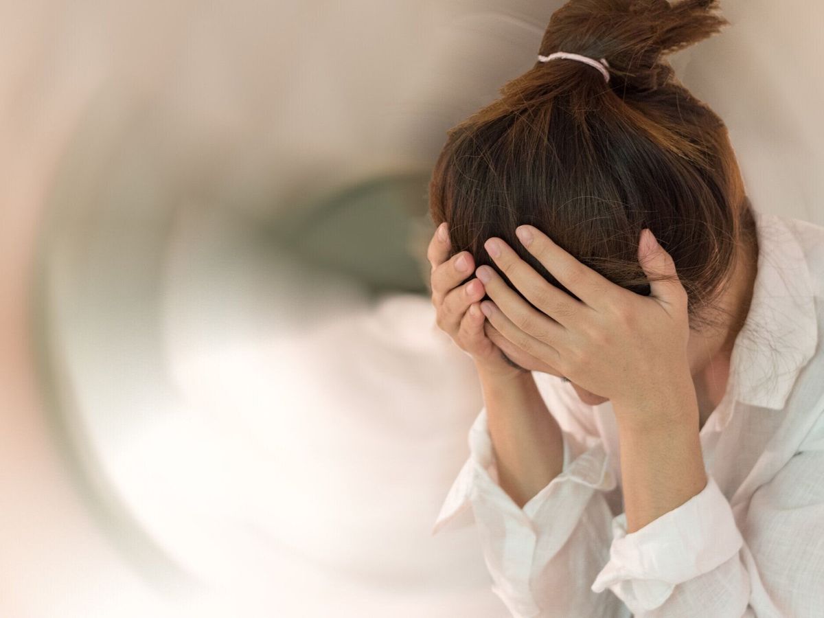 めまいの病気の概念。女性は頭の上に手を落とす頭痛のめまいのめまい感、内耳、脳、または感覚神経経路の問題。
