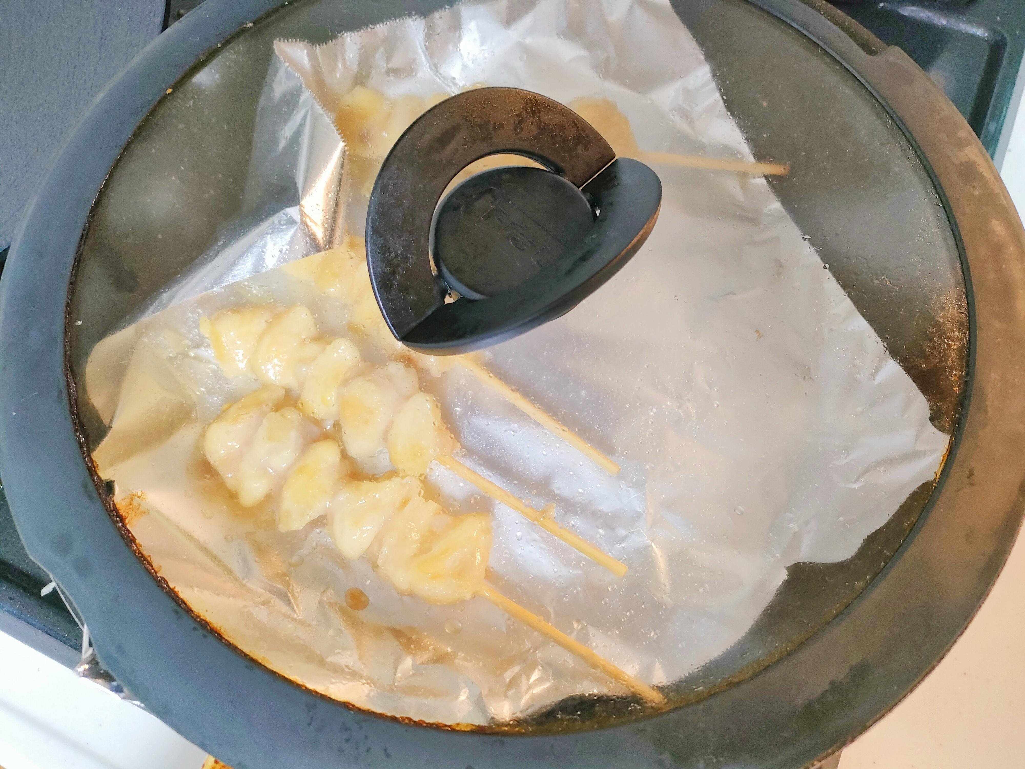 フライパンでぼんじり串を温める様子