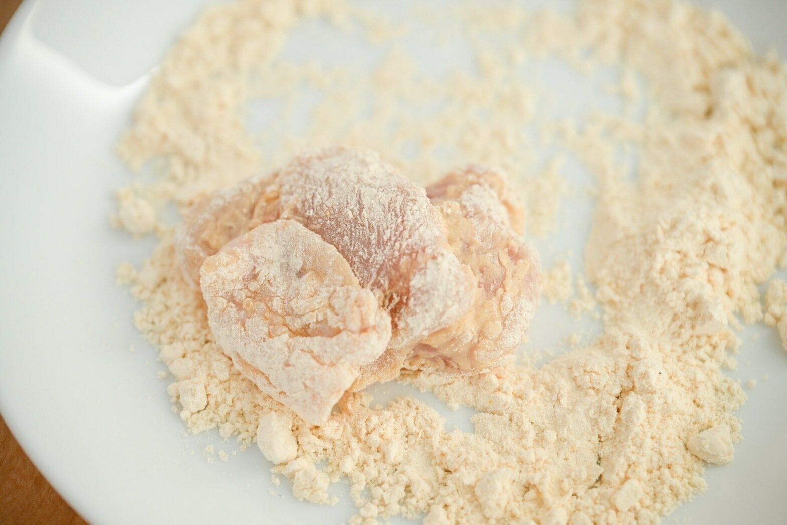 皿にのった粉をまぶした鶏もも肉