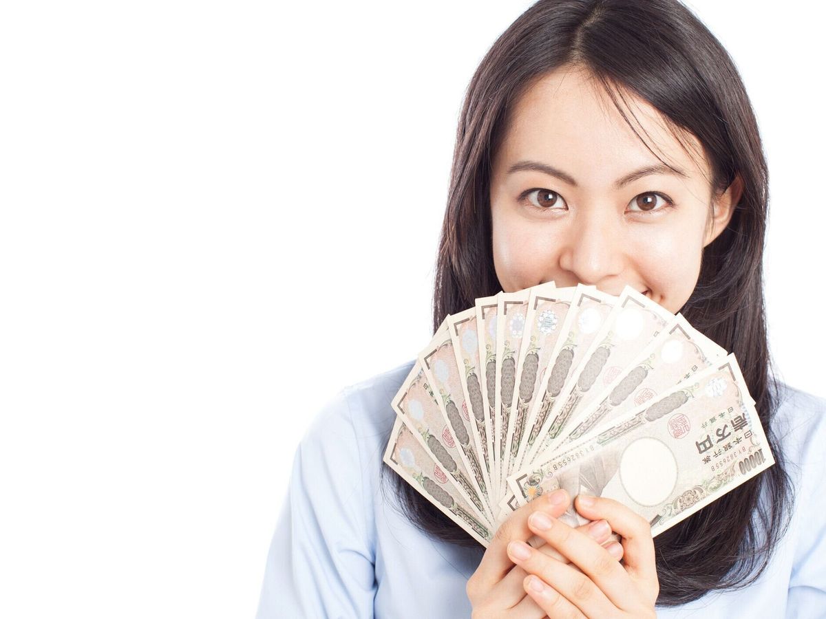 日本円を持つ日本人女性
