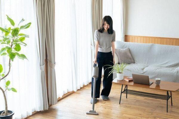 スッキリした空間で軽やかに掃除をする女性