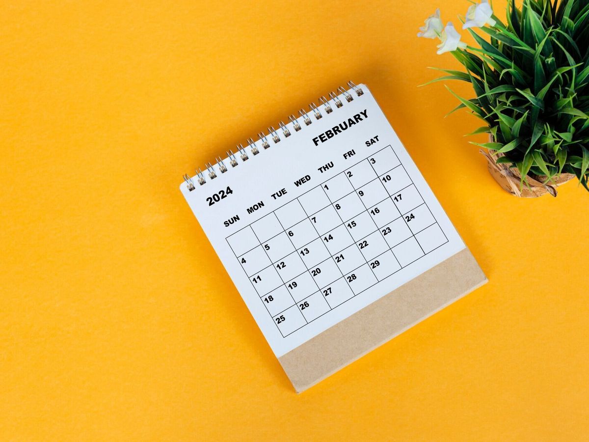 黄色の背景に2024年2月の卓上カレンダー。真上。フラットレイ。