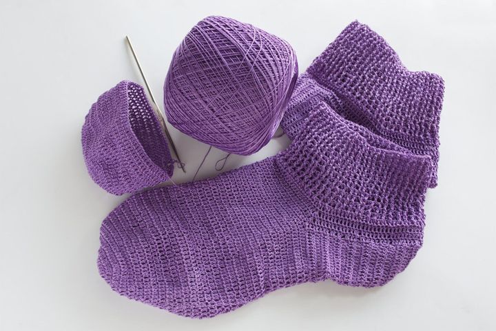 紫色の糸から作られた靴下。かぎ針編みが好きな人に人気のクラフトです。