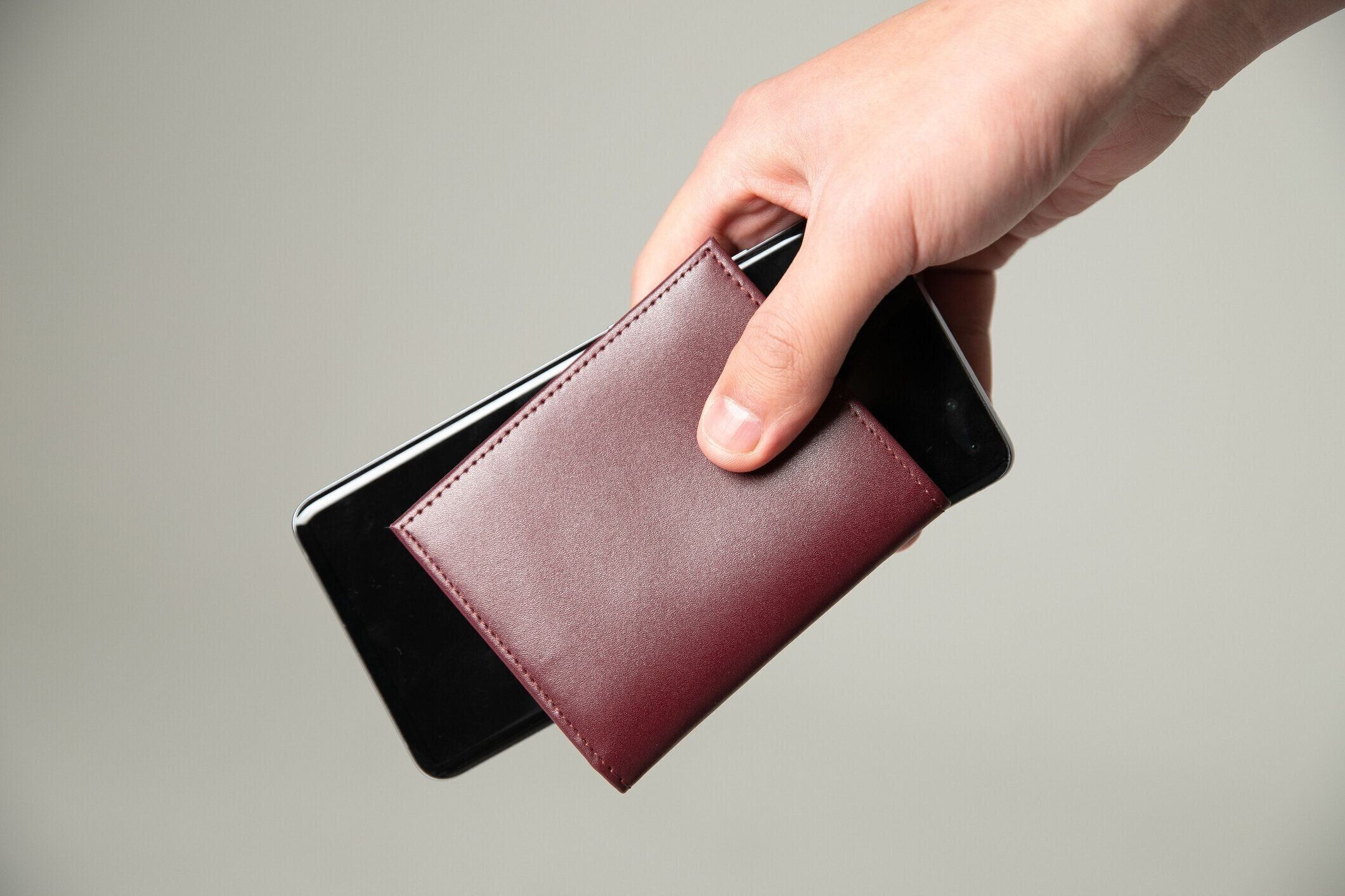革の財布と携帯電話を持つ手