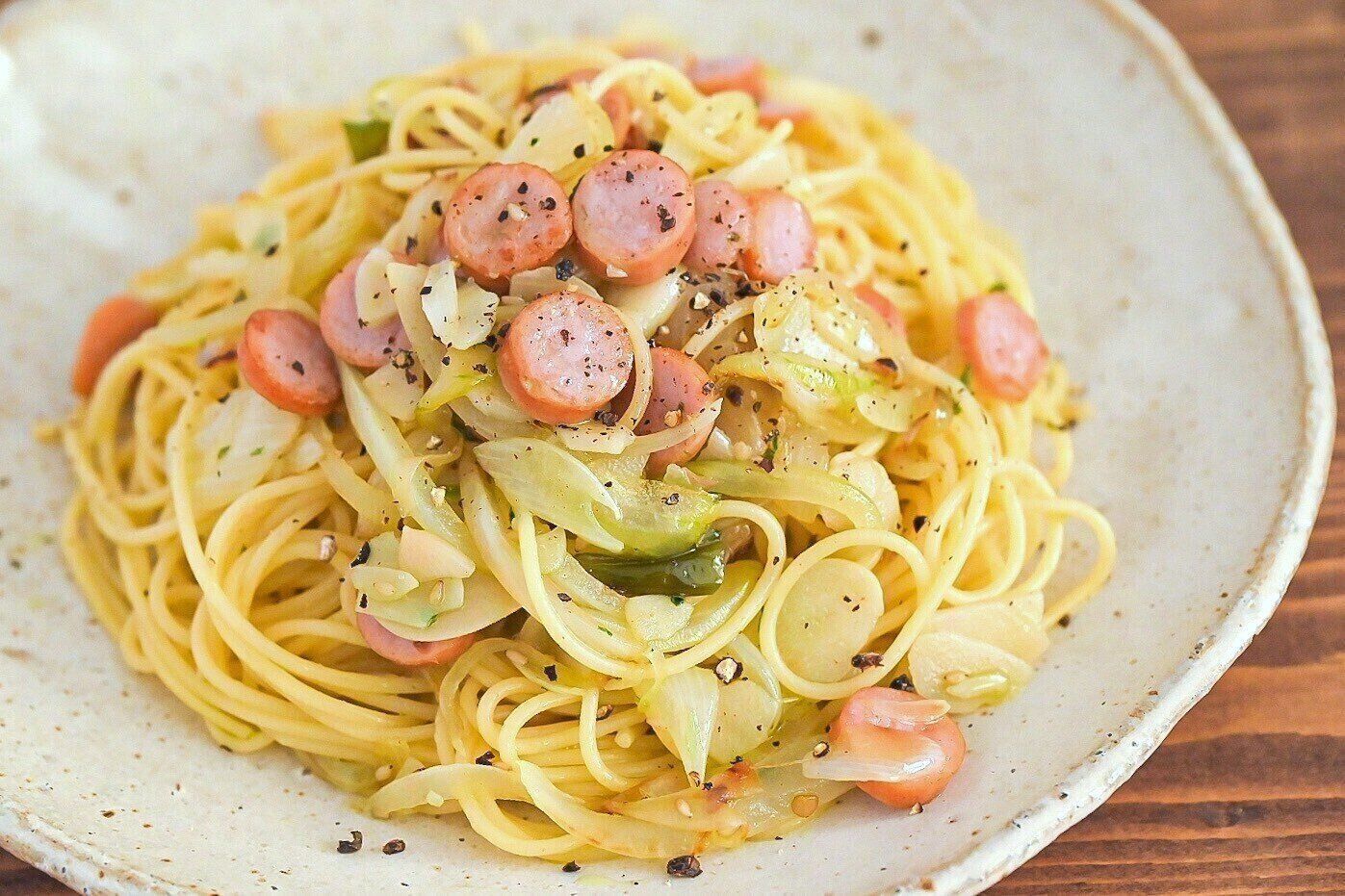 皿に盛られた玉ねぎとソーセージのパスタ