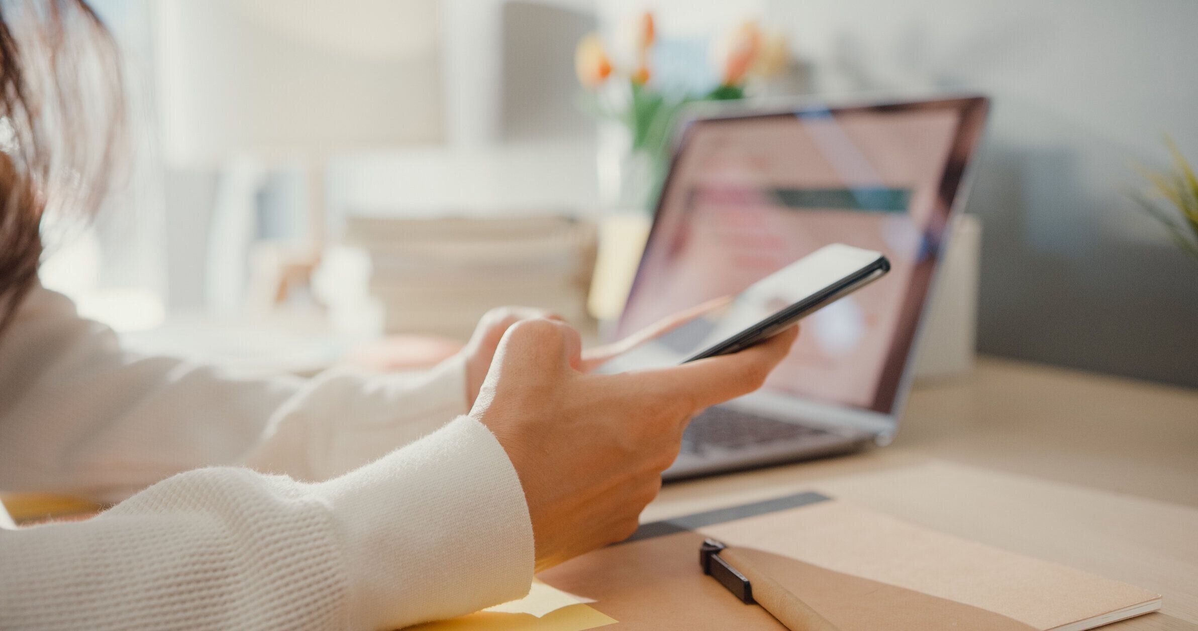 クローズアップ若いアジアの女性フリーランスは、自宅でラップトップで金融グラフチャート市場計画を働く同僚との仕事金融グラフチャート市場計画に焦点を当てた携帯電話チャット。女�