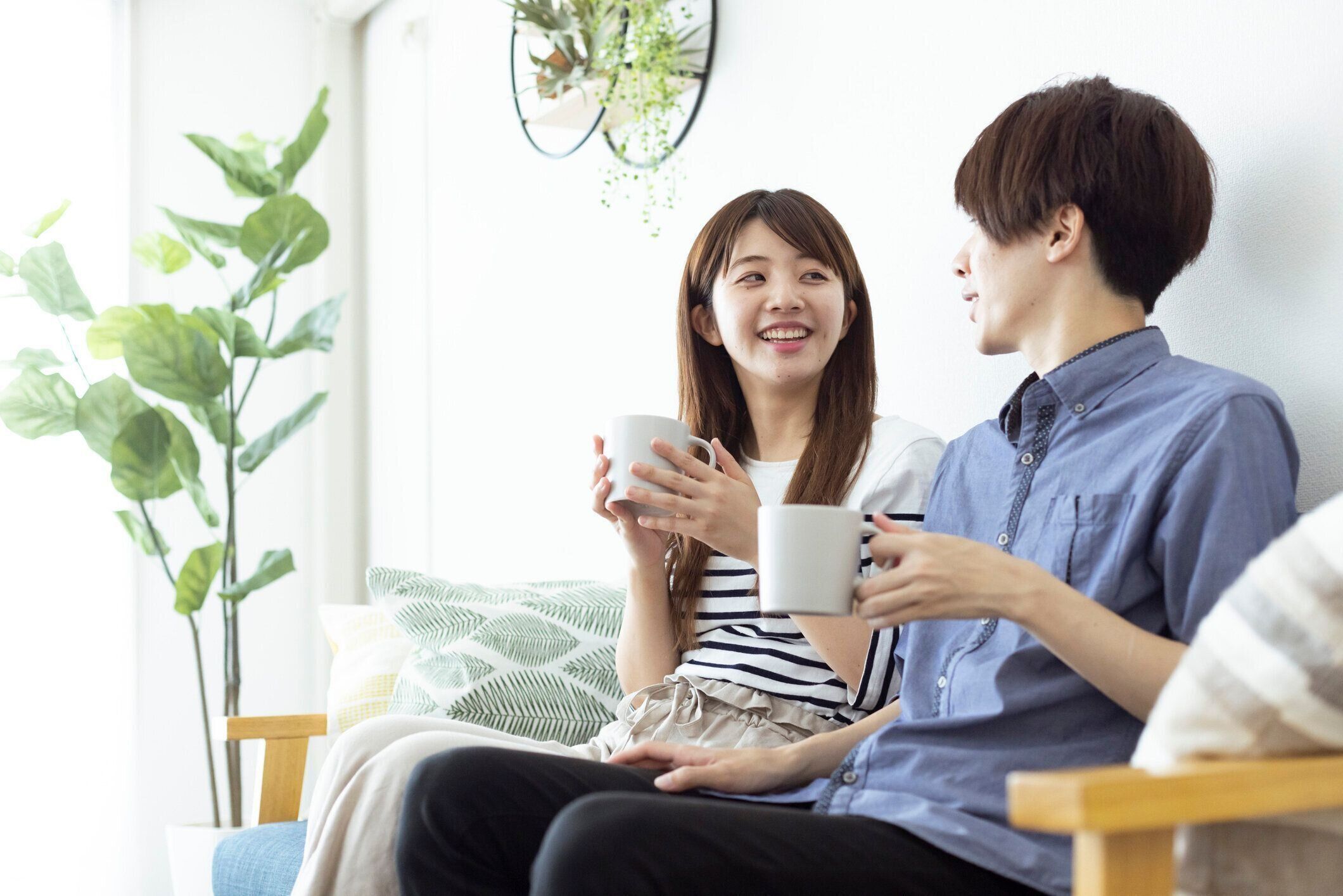 居間でリラックスした、見栄えの良い日本の男女