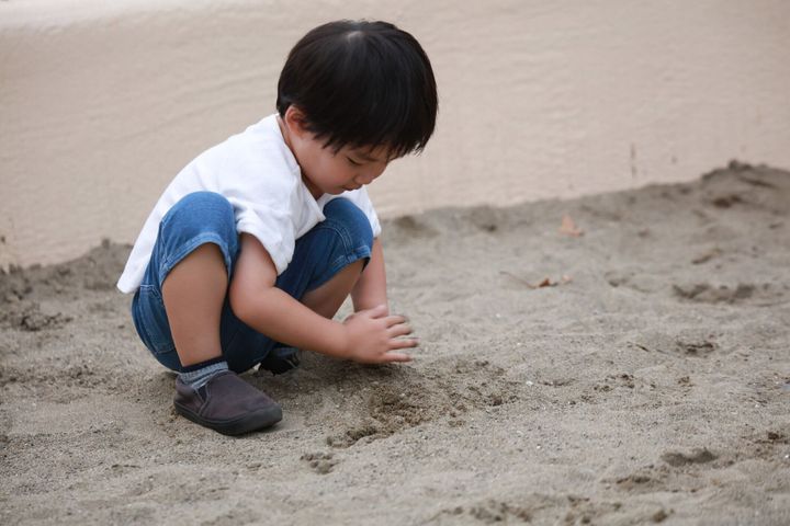 サンドボックスで遊ぶ少年