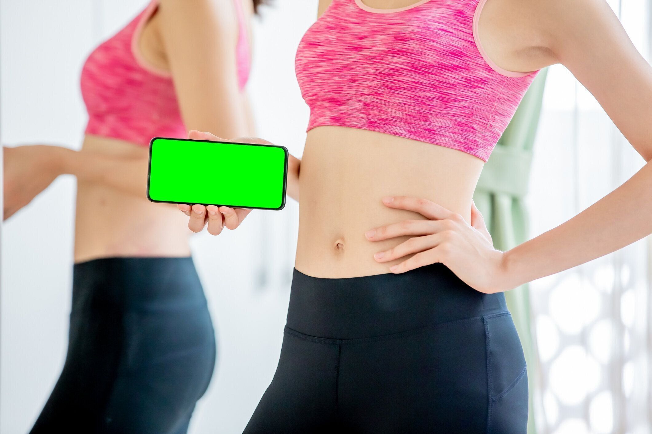 女性は緑の画面の携帯電話を示しています