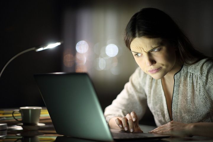 暗がりでPCを睨む女性
