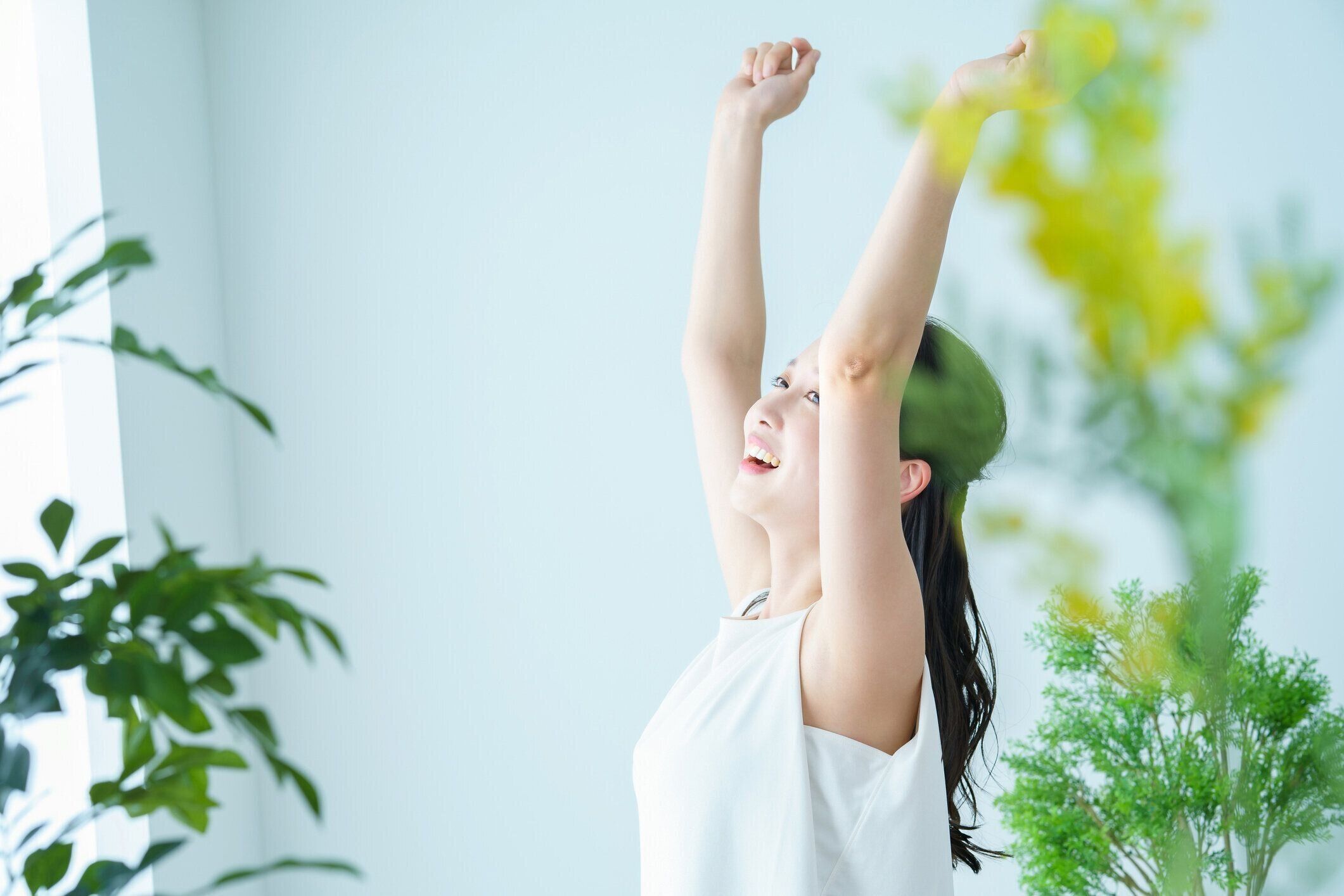 光を浴びながら深呼吸をする女性
