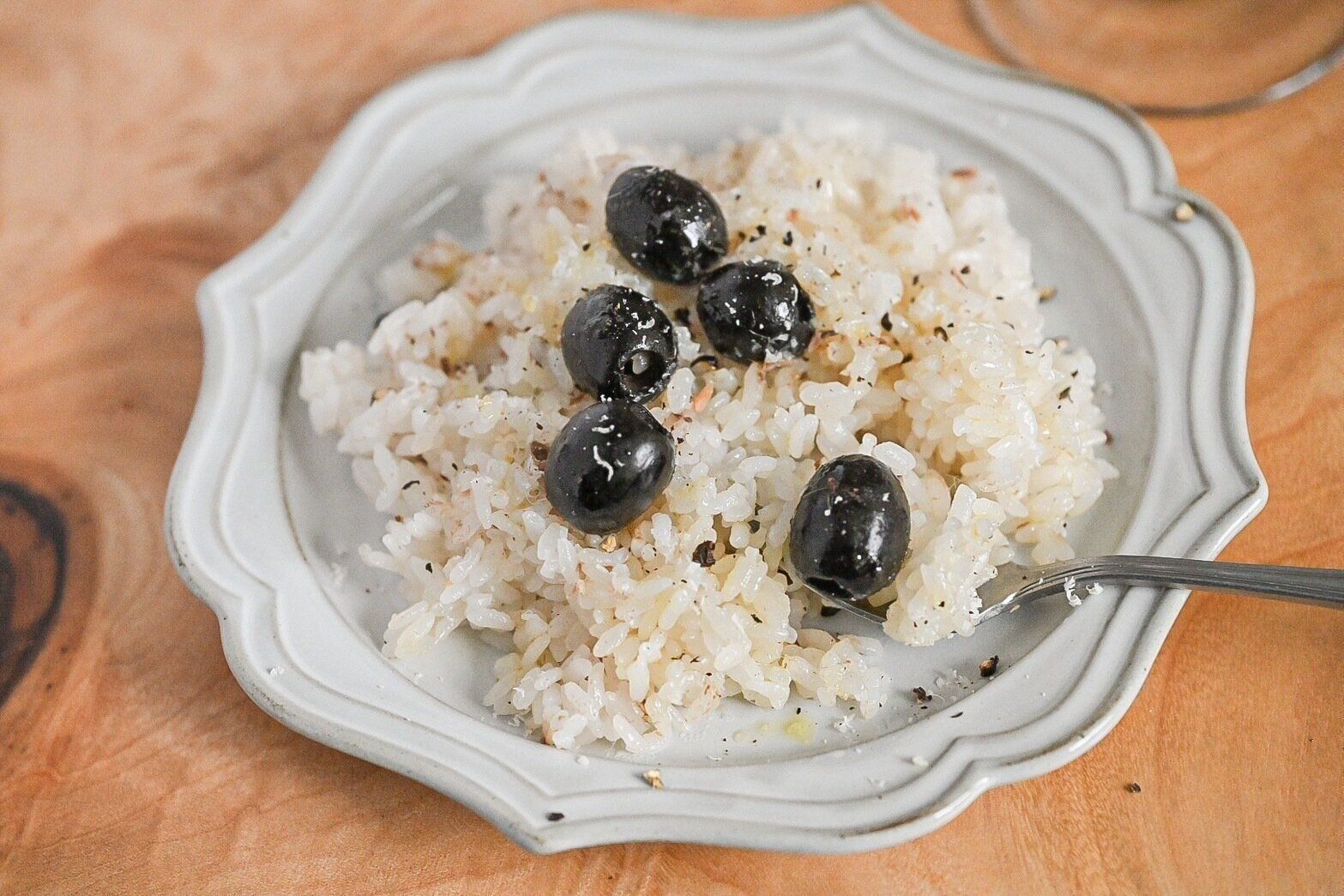 白い皿にのったオリーブとアンチョビの炊き込みごはん