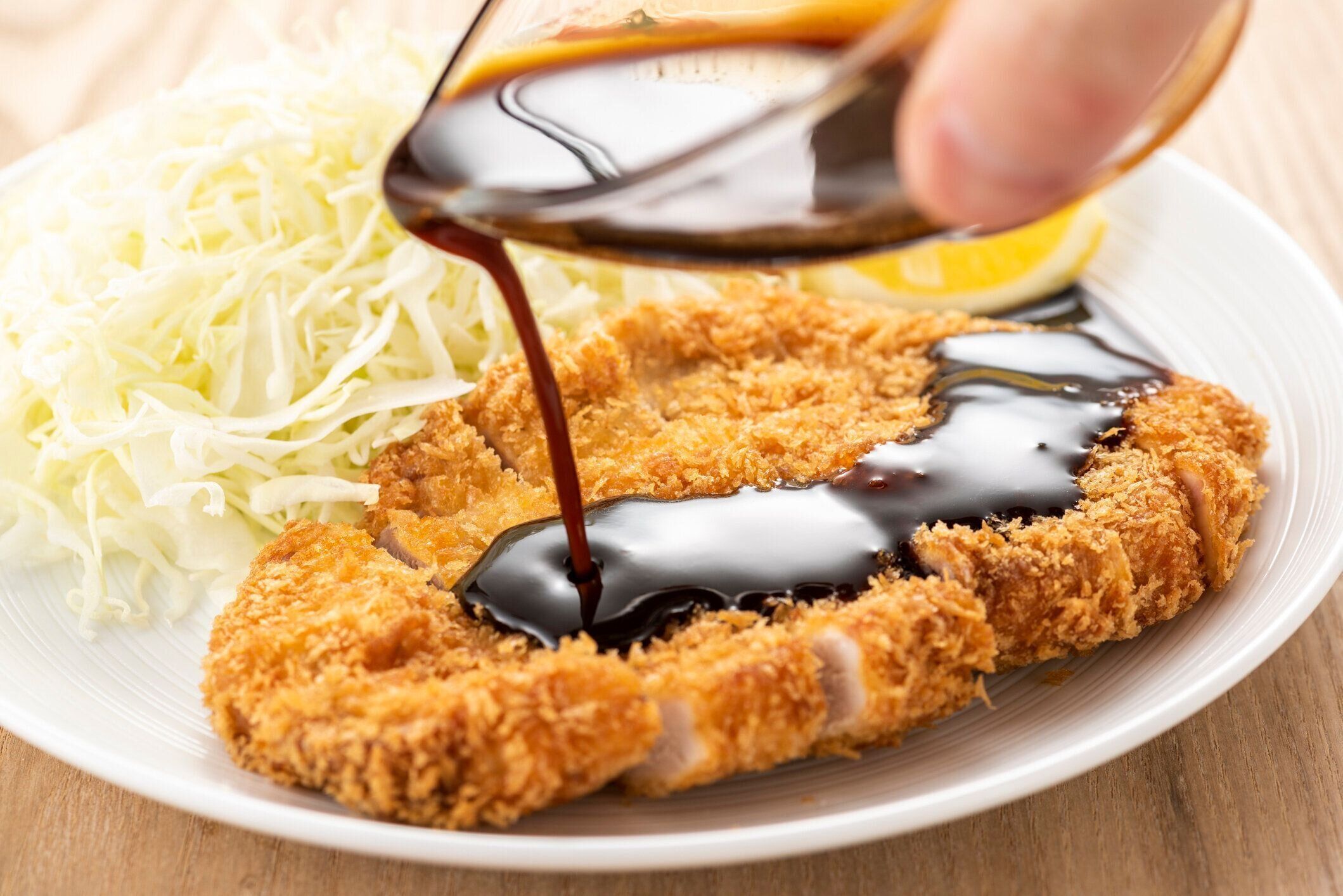 豚カツにソースを加える
