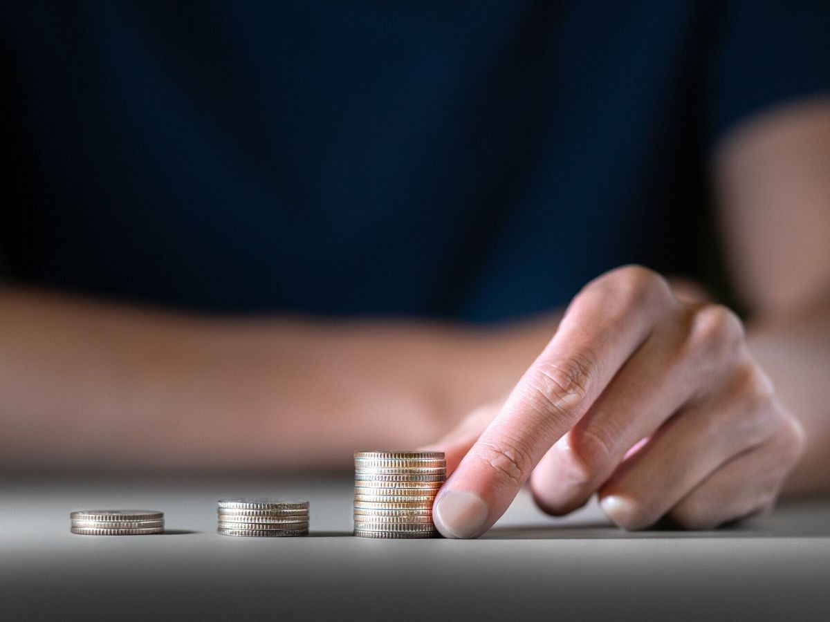 ビジネスマンは、マニーの富と金融コンセプト、ビジネスファイナンス投資、またはファンドとトレーディングで成長するためのファイナンシャルプランニングを節約するためにお金や金貨�