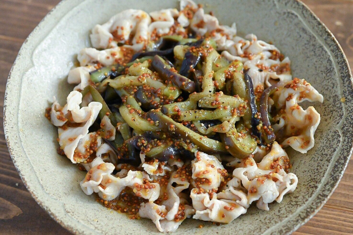 皿に盛られた豚肉となすの粒マスタードサラダ