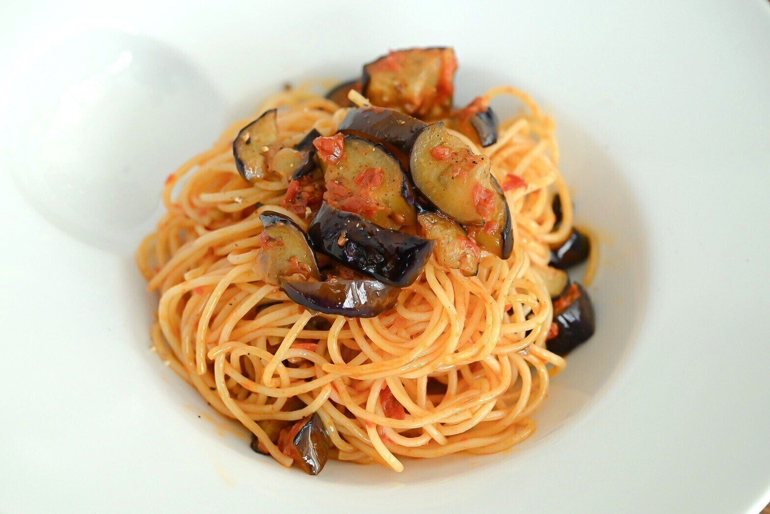 白い皿に盛られたなすのトマトパスタ