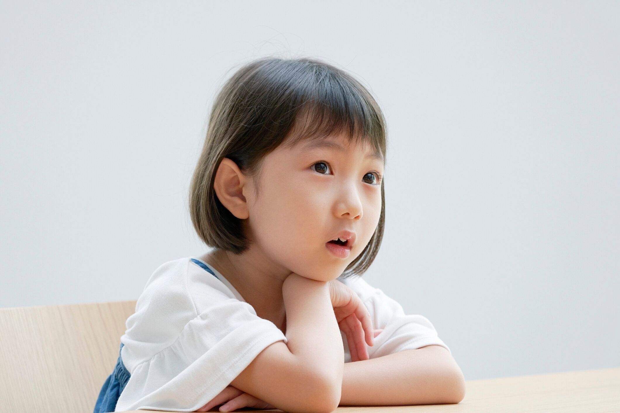 椅子の上で考えているアジアの女の子