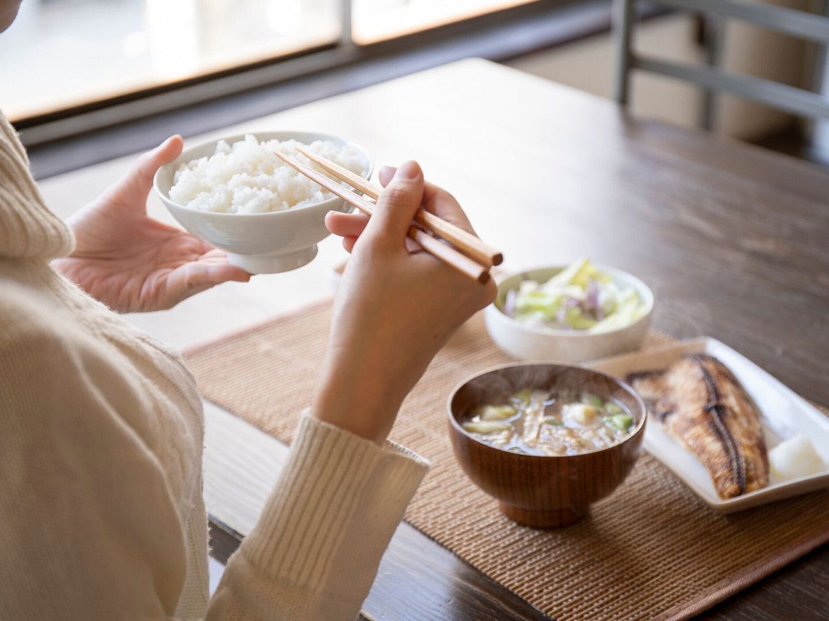 朝食を食べる若い女性の手