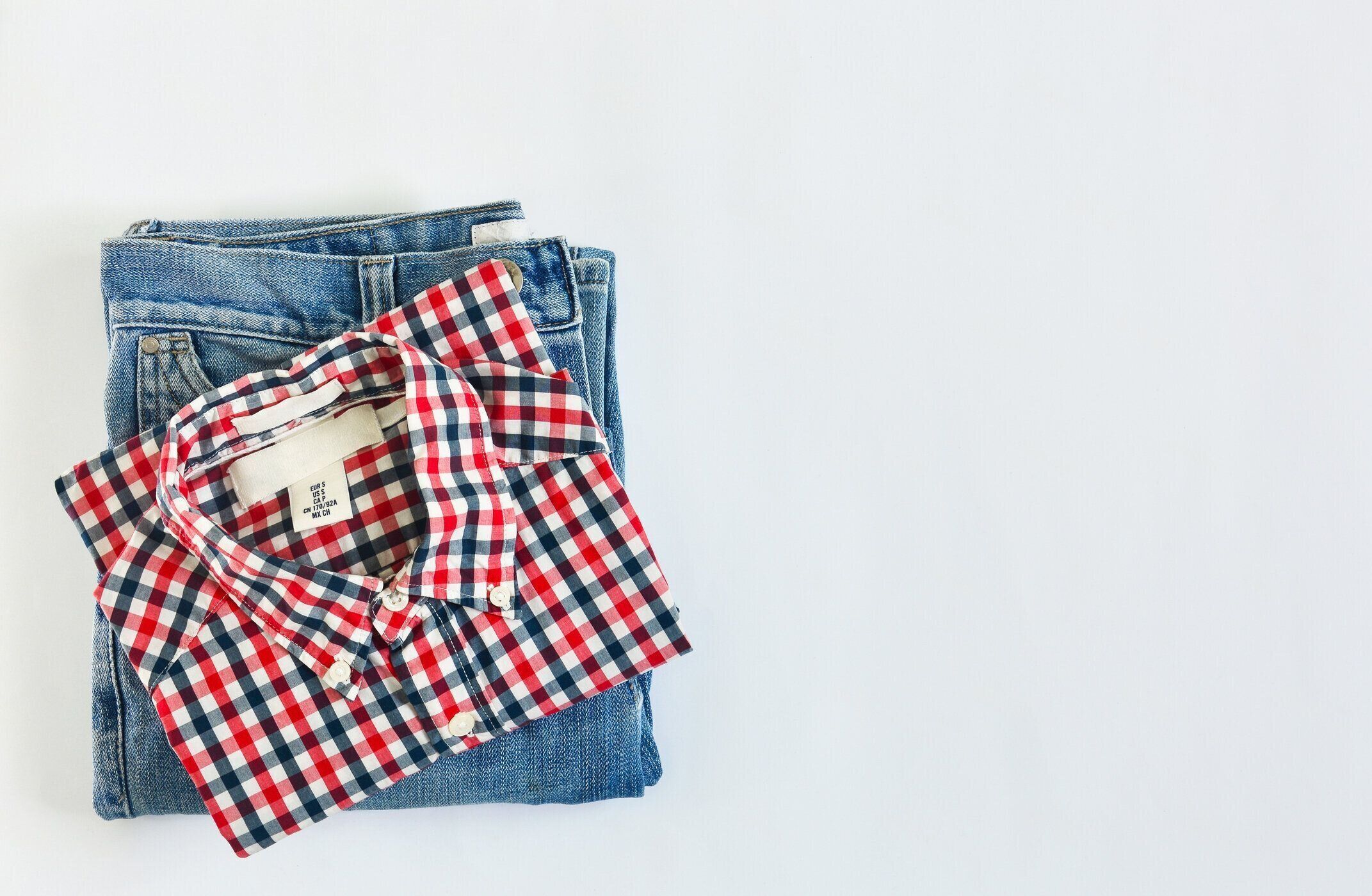 白い背景にチェック柄のシャツとジーンズのスタック