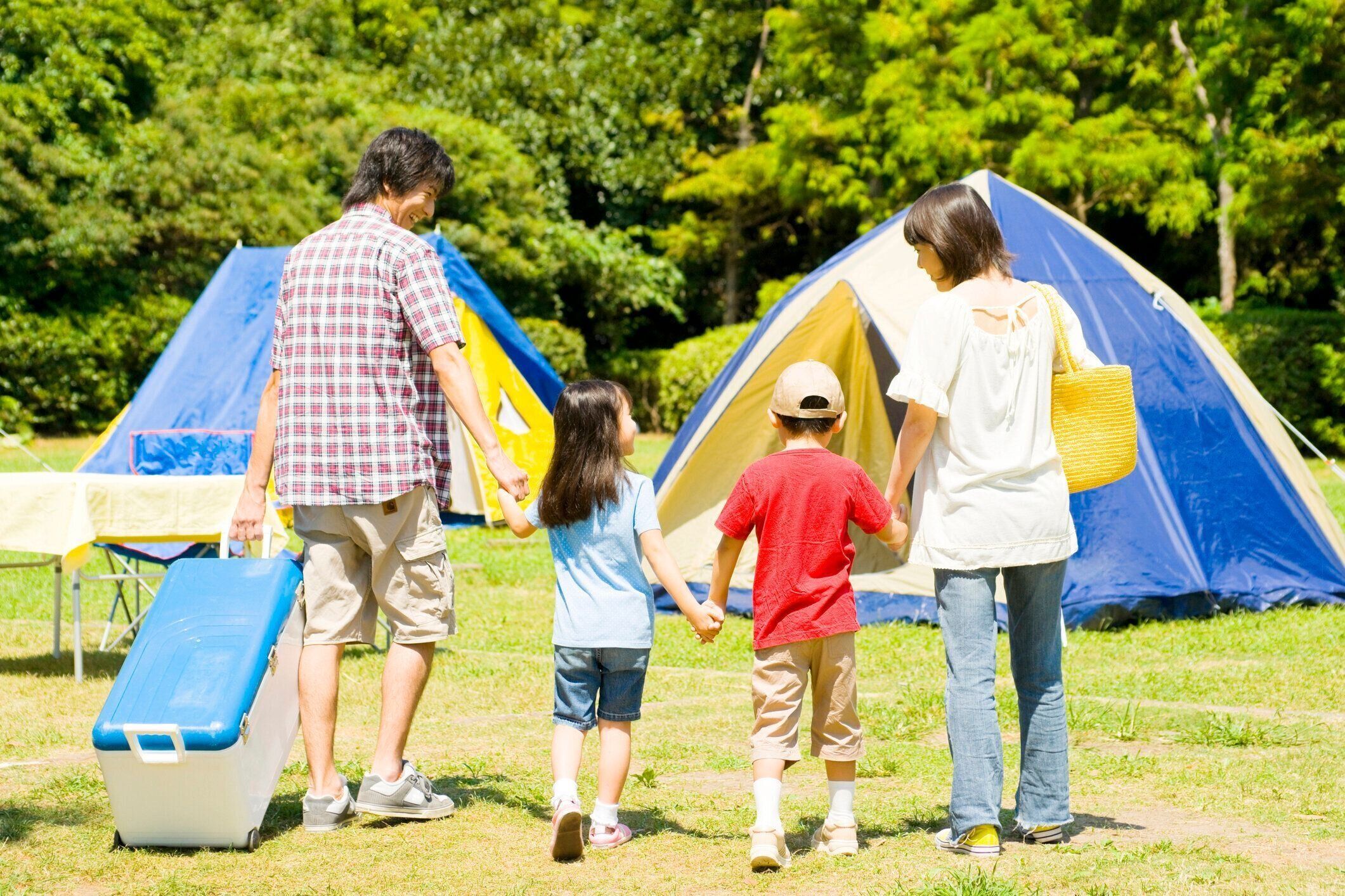 キャンプ場で手をつないで歩いて家族