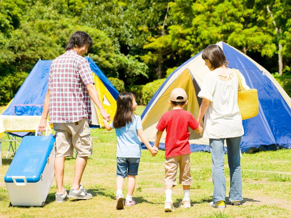 キャンプ場で手をつないで歩いて家族