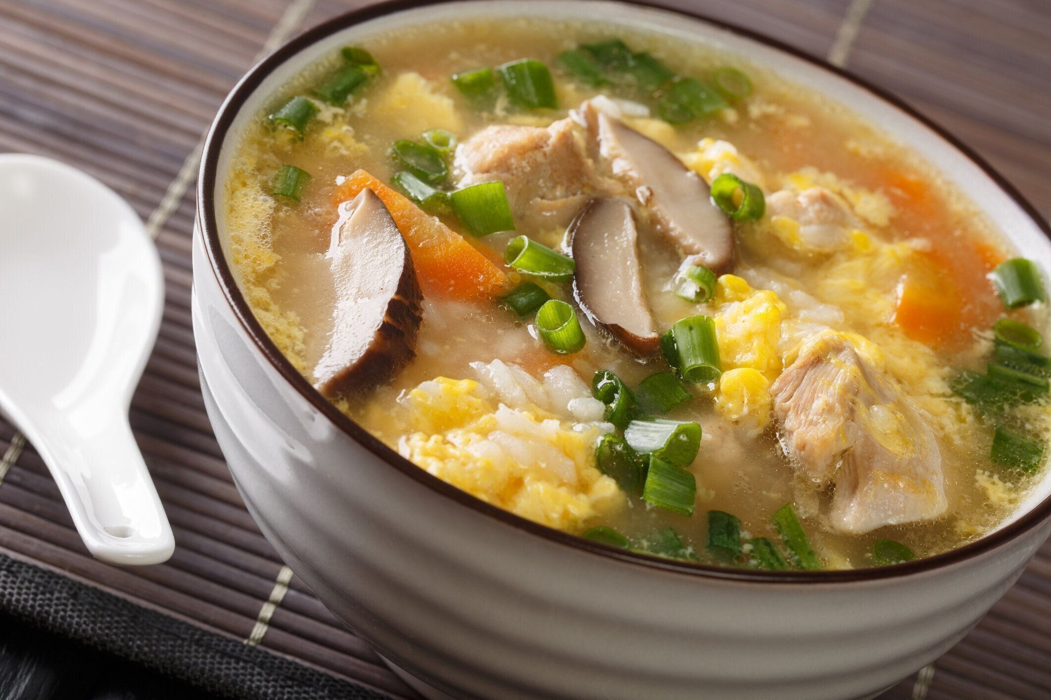 干水やおじやは、ボウルに卵、キノコ、野菜を閉じた穏やかで薄い日本の冬のライススープです。水平