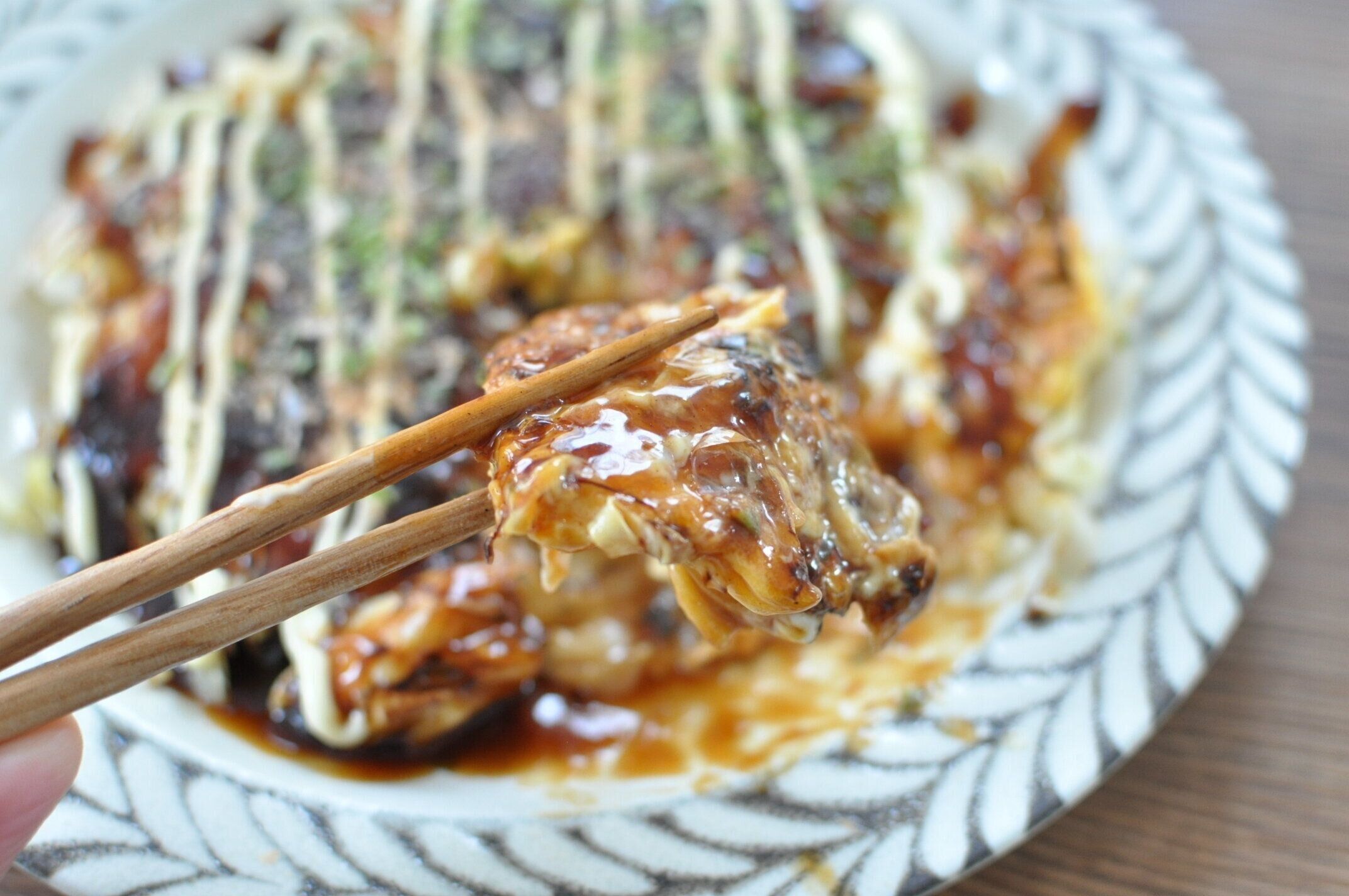 持ちお好み焼きを箸で持ち上げた様子