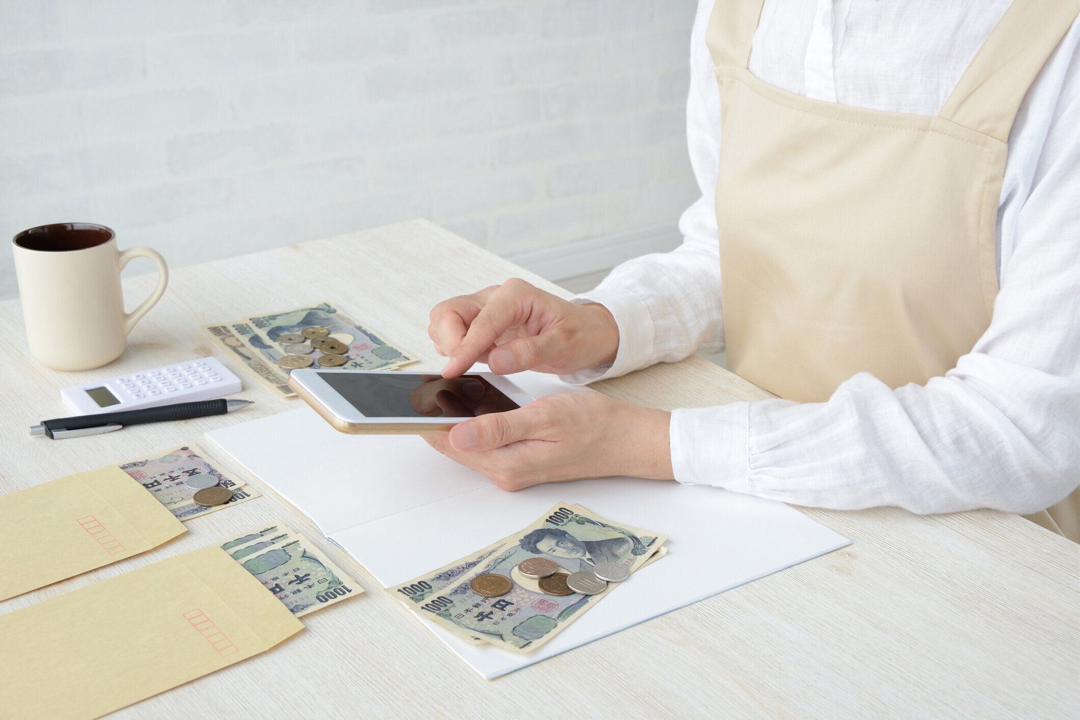 スマート フォンで家計簿を維持する日本人女性