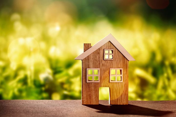 自然の背景の前に木造の住宅