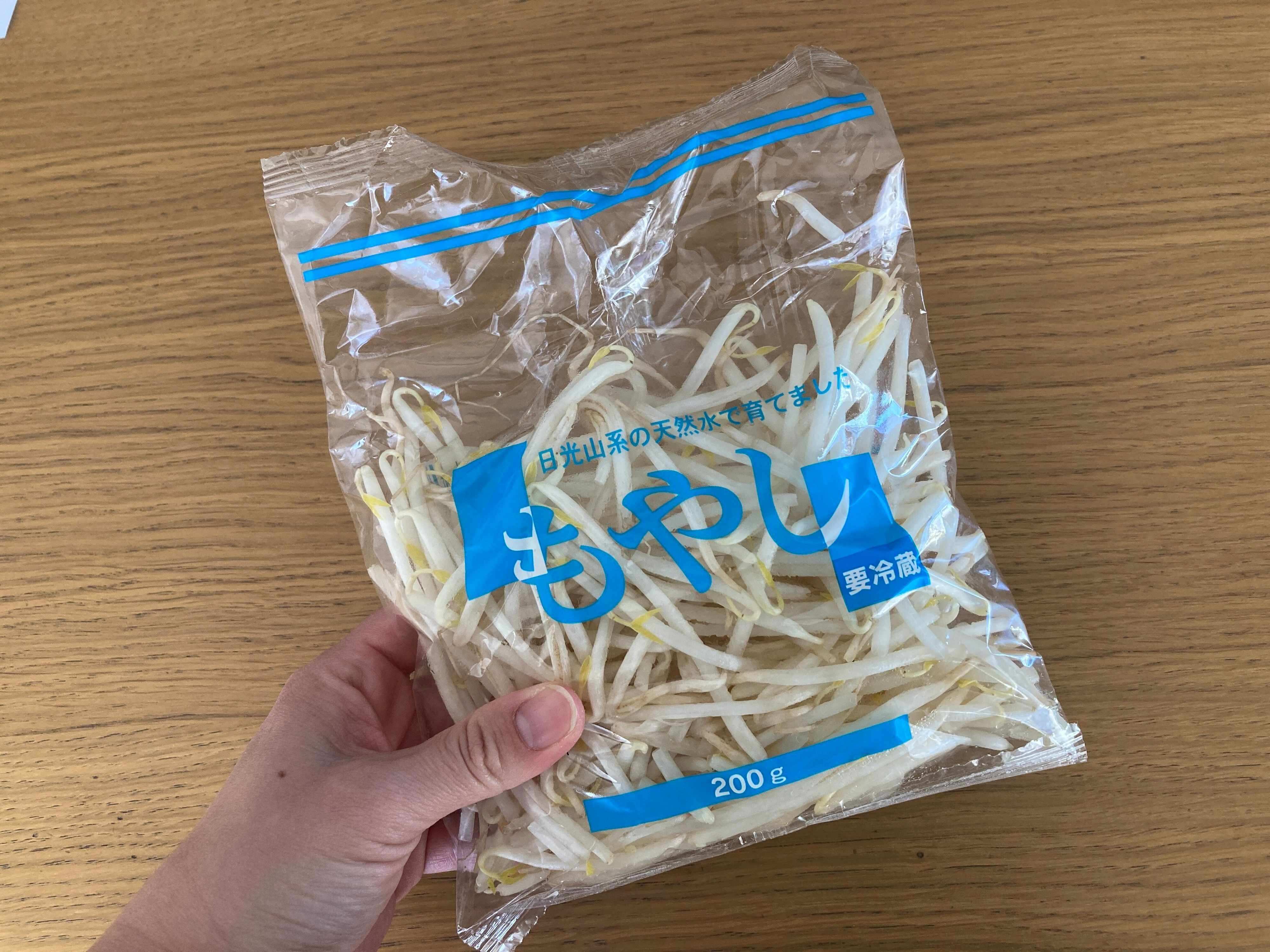 もやし1袋を手に持っている