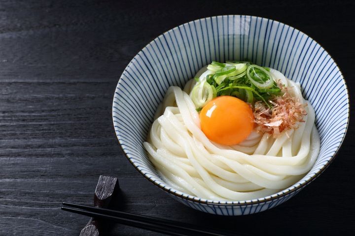 黒いテーブルに生卵が付くうどうも