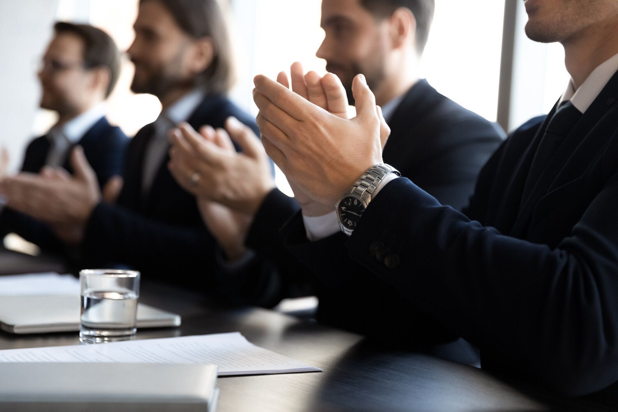 オフィスミーティングで拍手を送るビジネスマンのクローズアップ