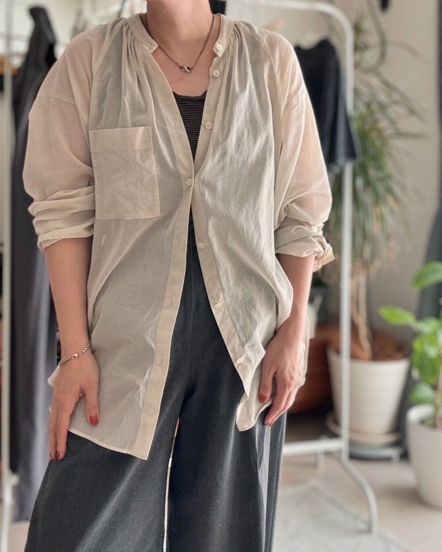 ベージュのシアーシャツとグレーパンツ