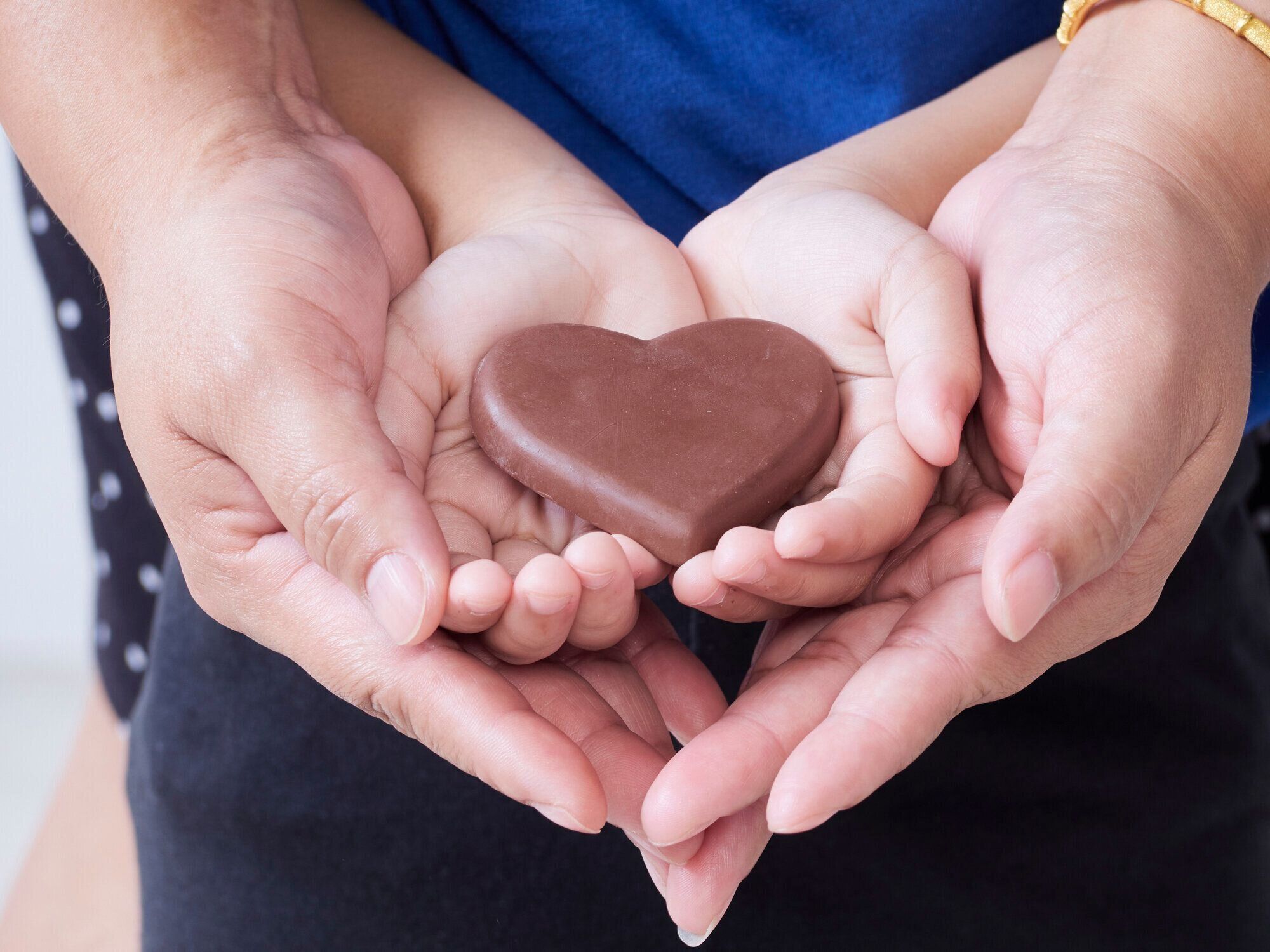 子供と母の手のチョコレートの心