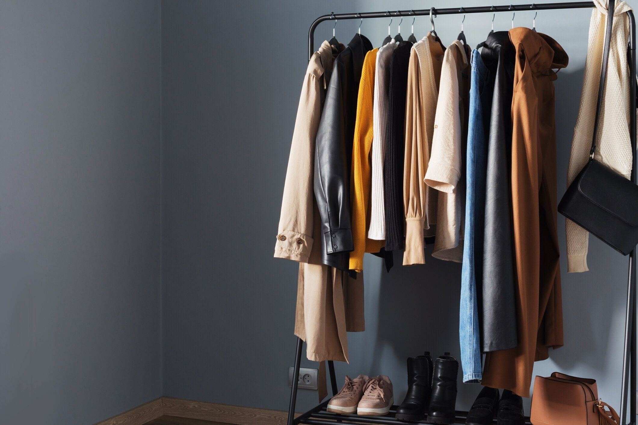ハンガーに靴とハンドバッグを置いた基本的な女性の秋のワードローブ