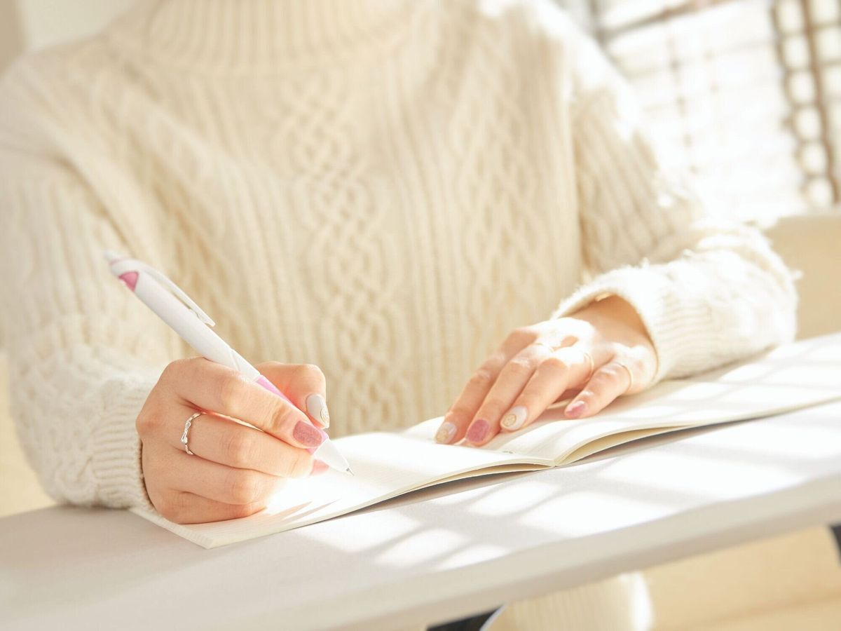 ノートをノートに入れる女性