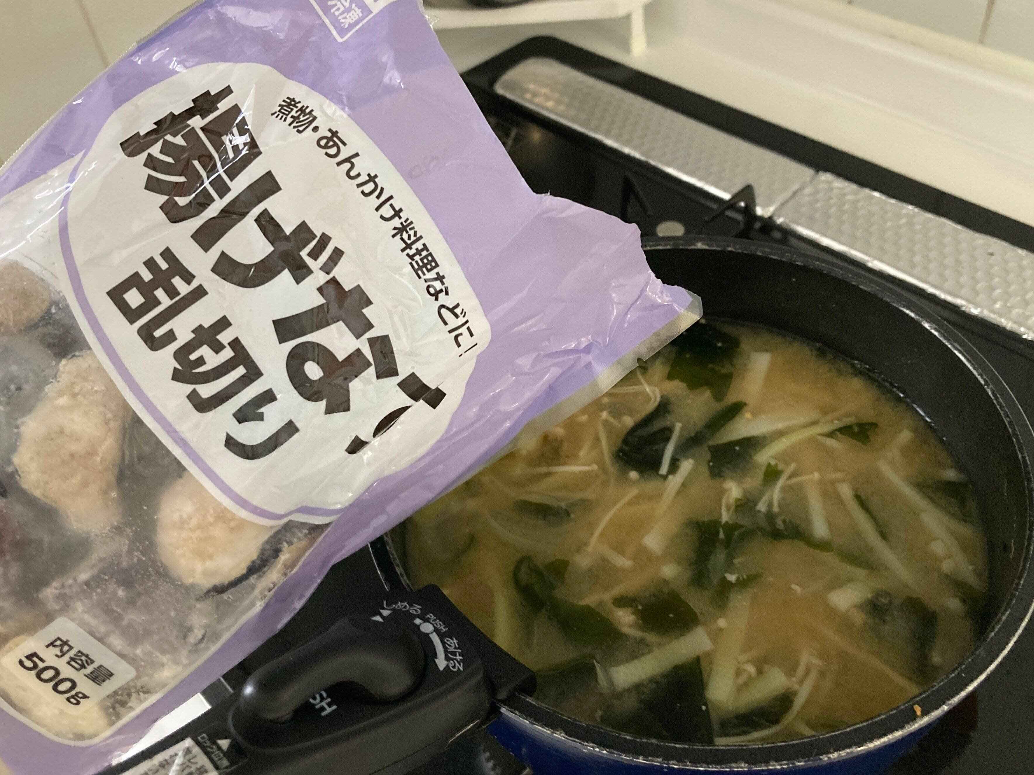 お味噌汁に冷凍の揚げなすを入れようとしているところ