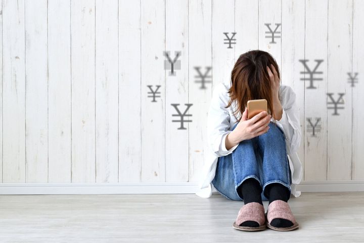 経済的問題を持つ座っている女性の画像