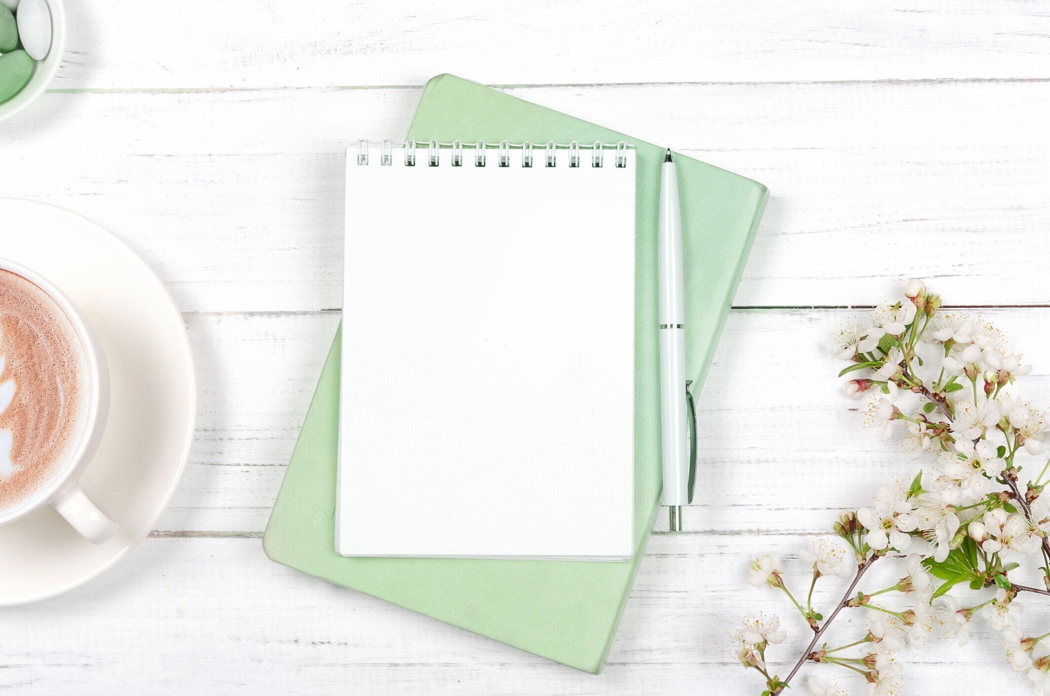 ワークスペースデスクの創造的なフラットレイ、木製の背景にメモ帳