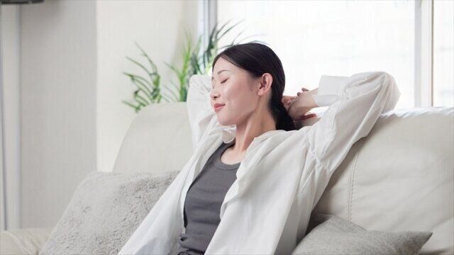 ソファで伸びをする女性