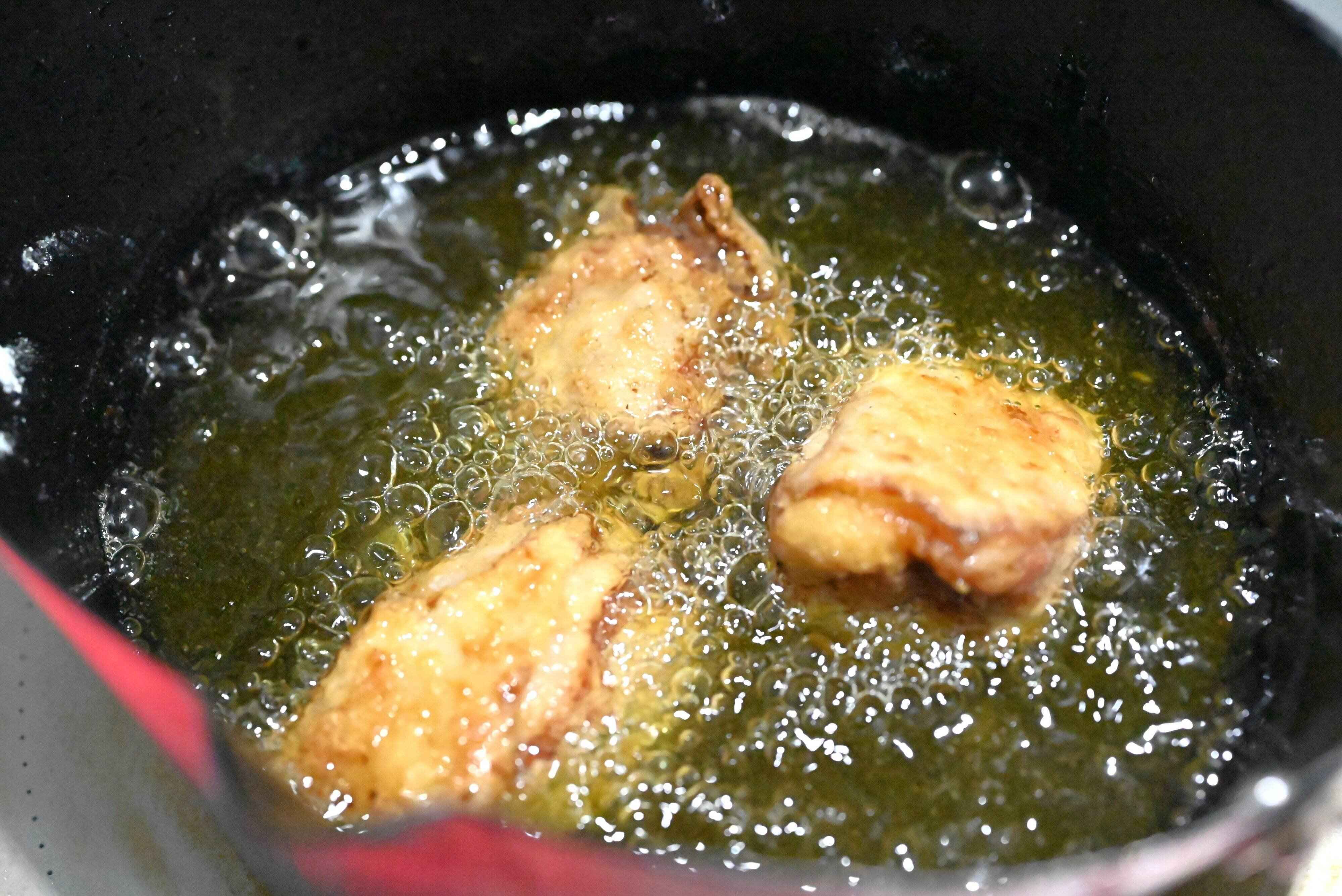 揚げ油に入った唐揚げ