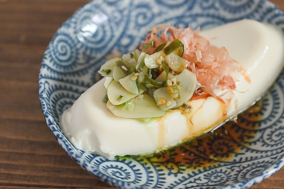 皿に盛られた「青いにんにく辣油」をのせた豆腐