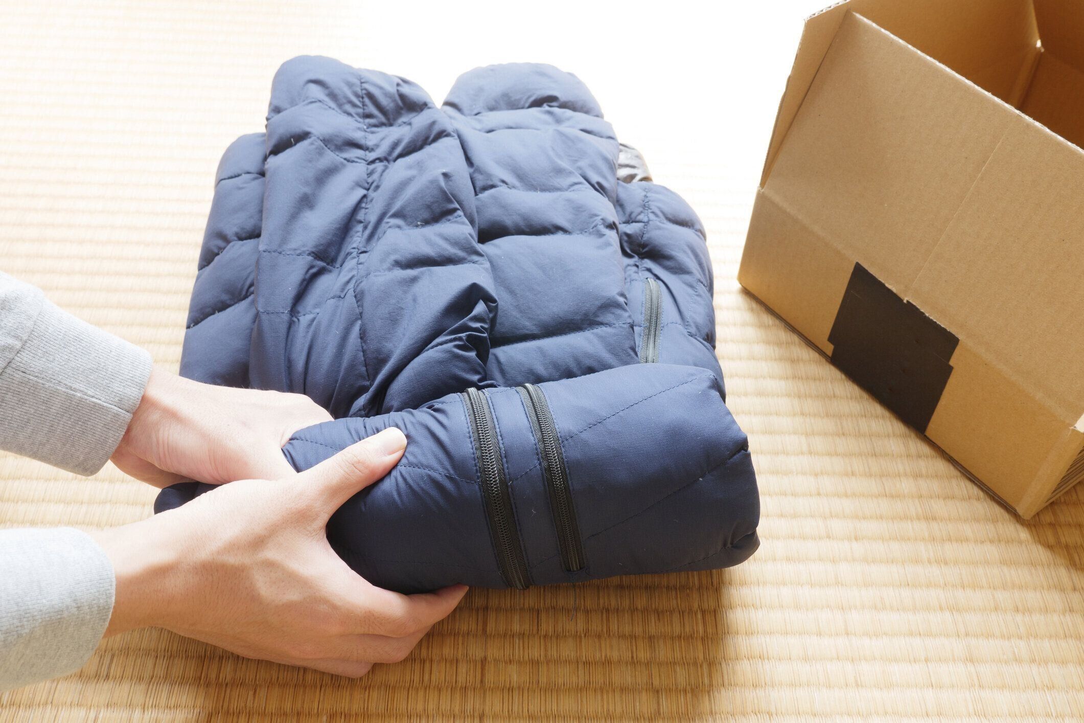 ダウンジャケットをコンパクトにして段ボール箱に入れ