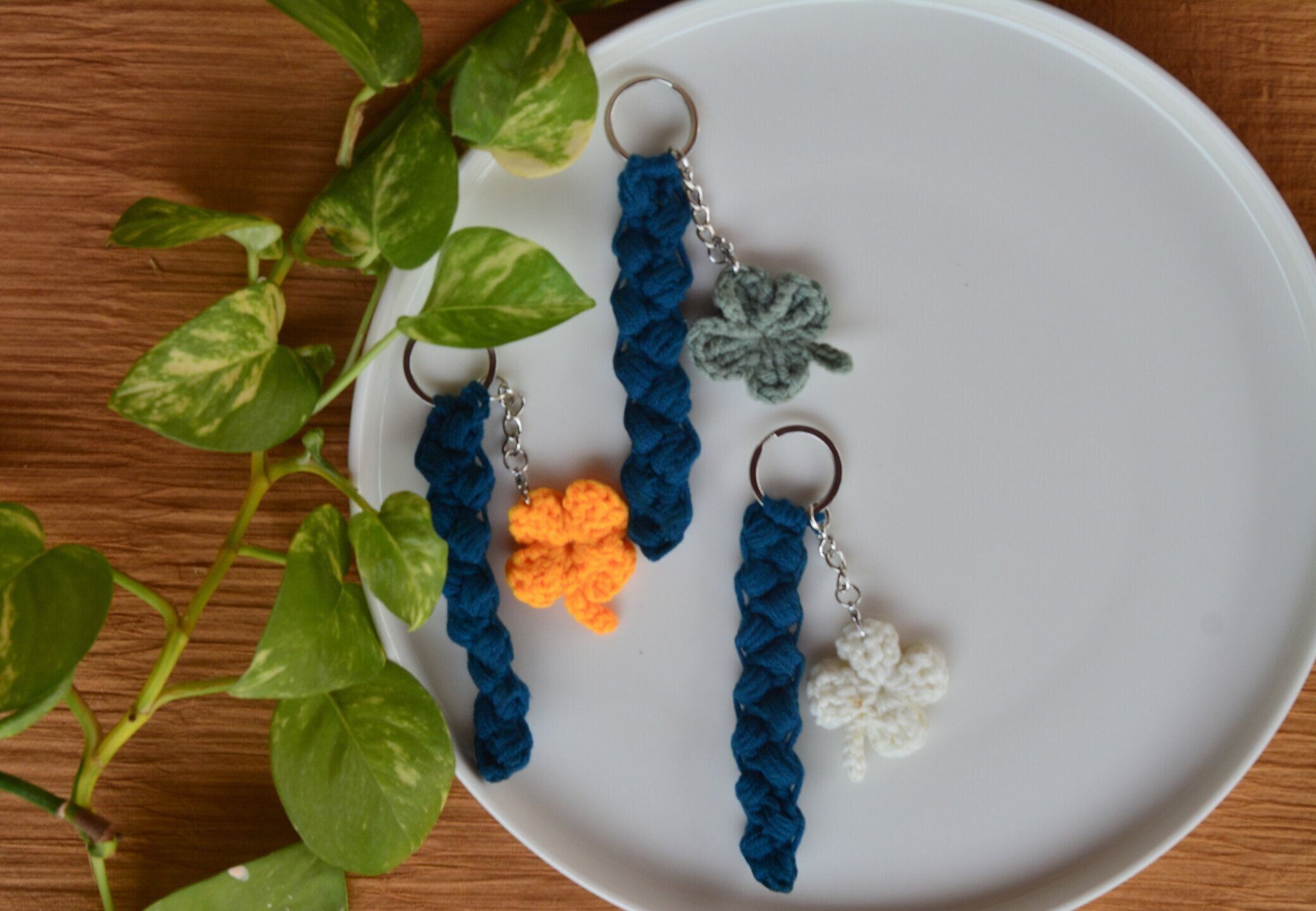 白と茶色の背景に手作りのカラフルかぎ針編みのシャムロックキーホルダー、カラフルかぎ針編みのシャムロック、ラッキーチャーム