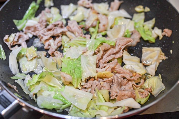 フライパンに入った豚肉とキャベツ