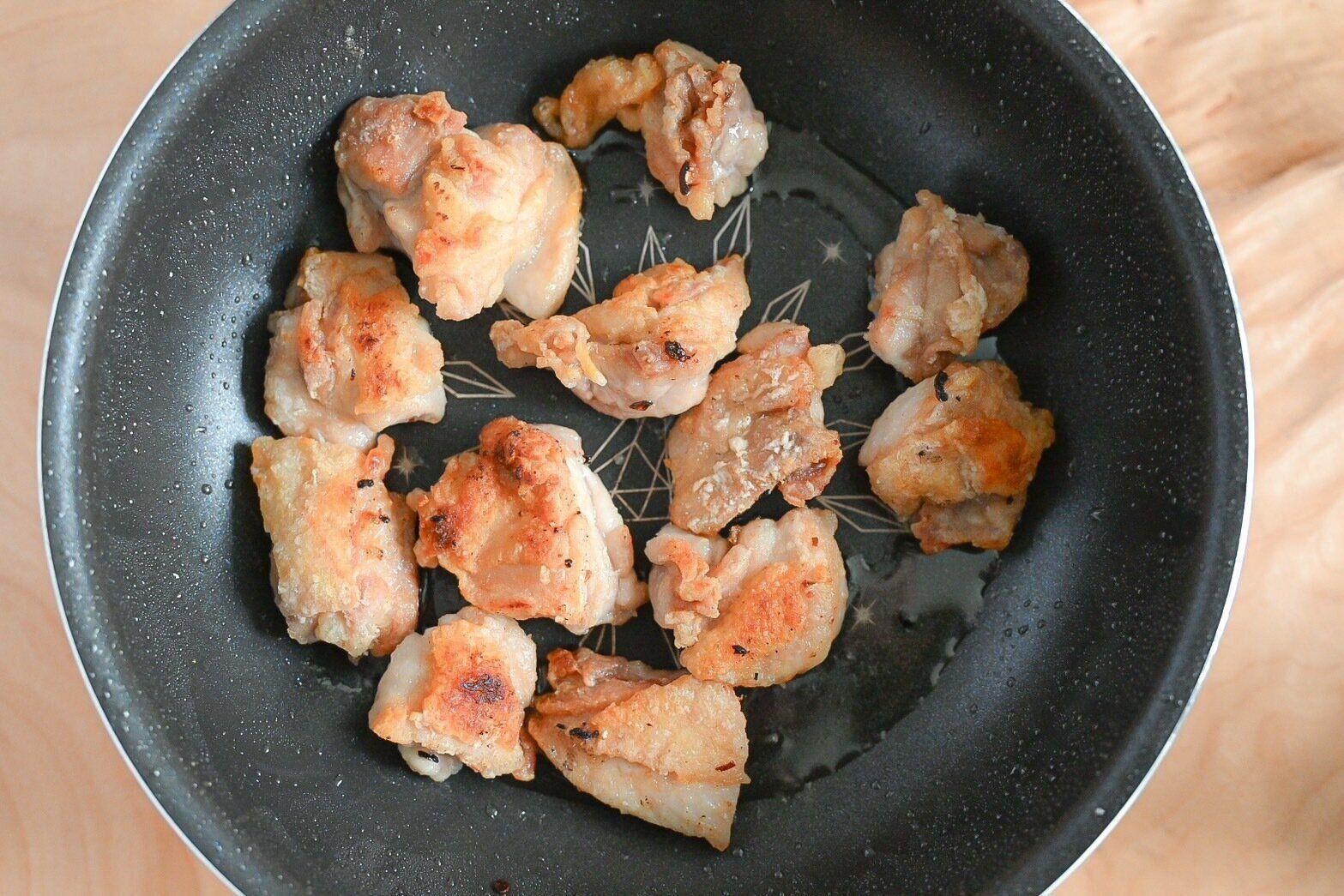 フライパンに入った焼き色が付いた鶏もも肉