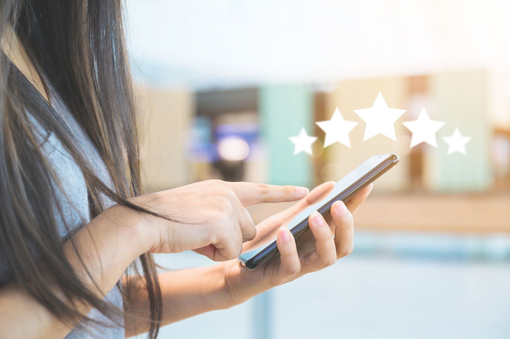 カスタマーサービスの経験とビジネス満足度調査。アイコン5つ星のシンボル付き携帯電話を使用して、会社のコンセプトの評価を高める女性の手のクローズアップ画像