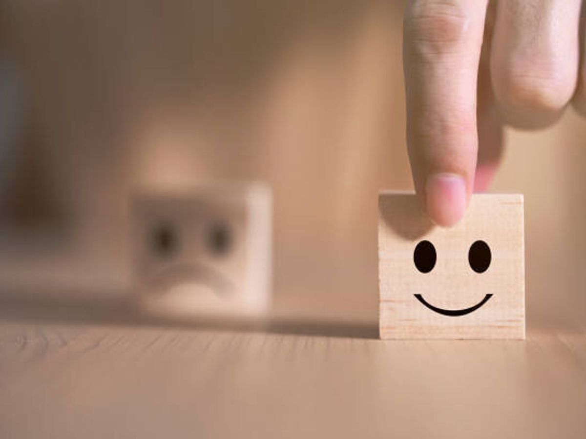 ビジネスマンは、木製のブロック、サービスと顧客満足度調査のコンセプトに幸せなシンボルに直面する笑顔の絵文字アイコンを選択します