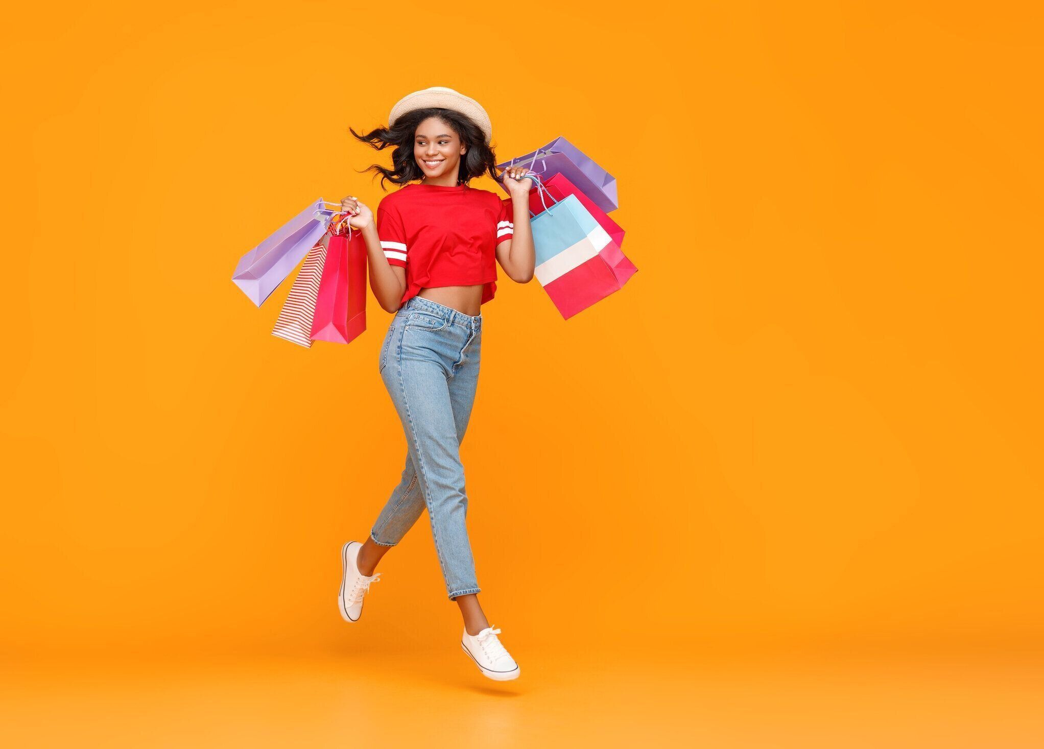 買い物の購入の概念と黄色の背景にパッケージを持つ幸せな女の子の販売